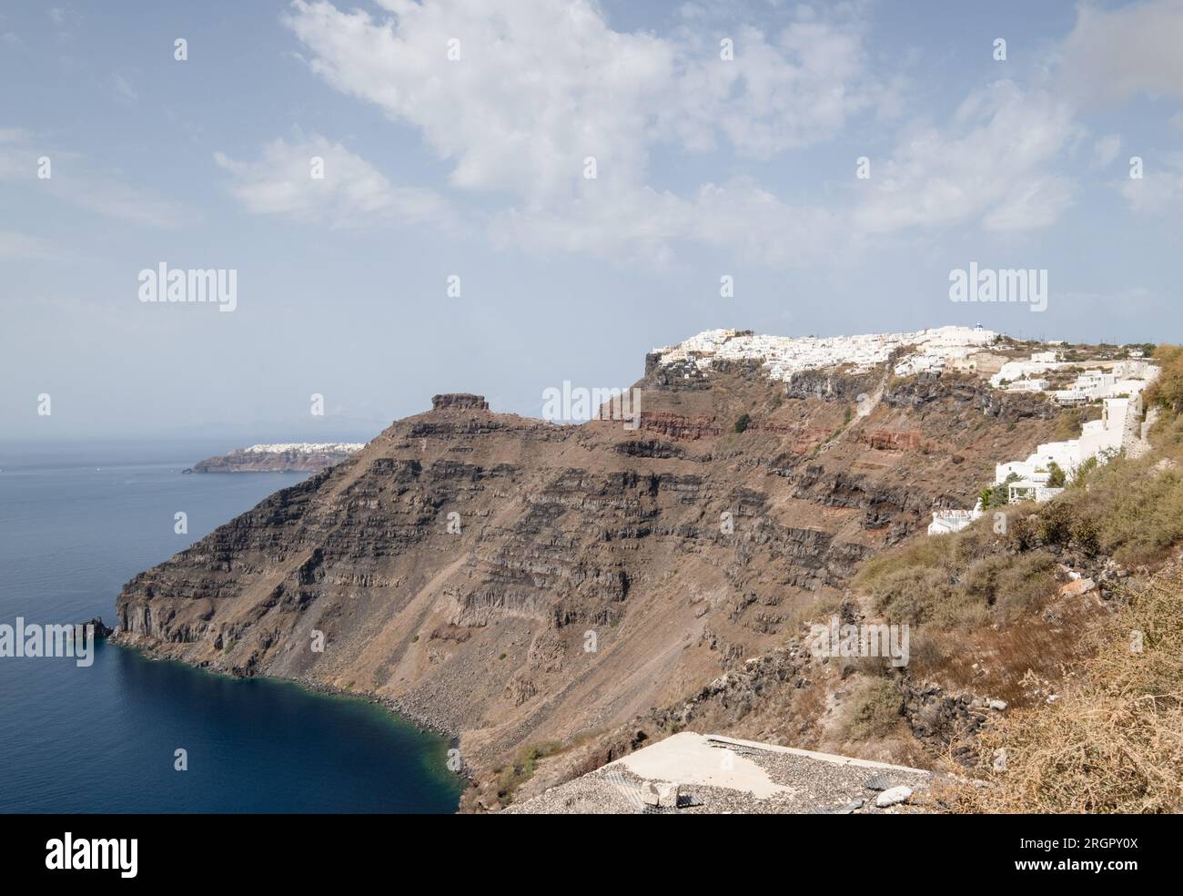 Mit Blick auf den Wanderweg von Thera nach Oia, mit Gebäuden auf der Spitze der felsigen Insel. Stockfoto