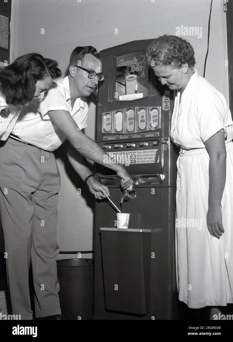 1950er, historisch, neuer Verkaufsautomat, „Snack Bar; USA. Getränke verfügbar, schwarzer Kaffee, Kaffee mit Sahne, heiße Coca & Chicken Bouillon Suppe. Jedes Heißgetränk kostet 10 Cent und man kann ein oder zwei Cent einstecken! Die erste kommerzielle Nutzung von Verkaufsautomaten wurde Ende der 1880er Jahre entwickelt, um Kaugummi auf Bahnhöfen zu verkaufen, wobei ab Anfang der 1900er Jahre alkoholfreie Getränke angeboten werden. Kaffee- und Heißgetränkehändler kamen seit den späten 1940er Jahren auf den Markt. Man sagt, dass der erste Automat von Hero Alexandria erfunden wurde, als er Weihwasser ausgab. Stockfoto
