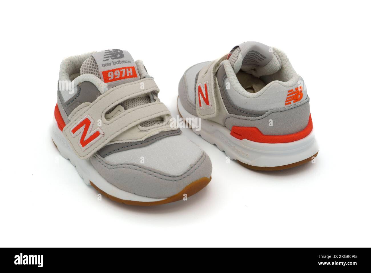 Paar weiße, winzige New Balance 997H Sneakers für Babys, die isoliert auf weißem Hintergrund ausgeschnitten sind Stockfoto