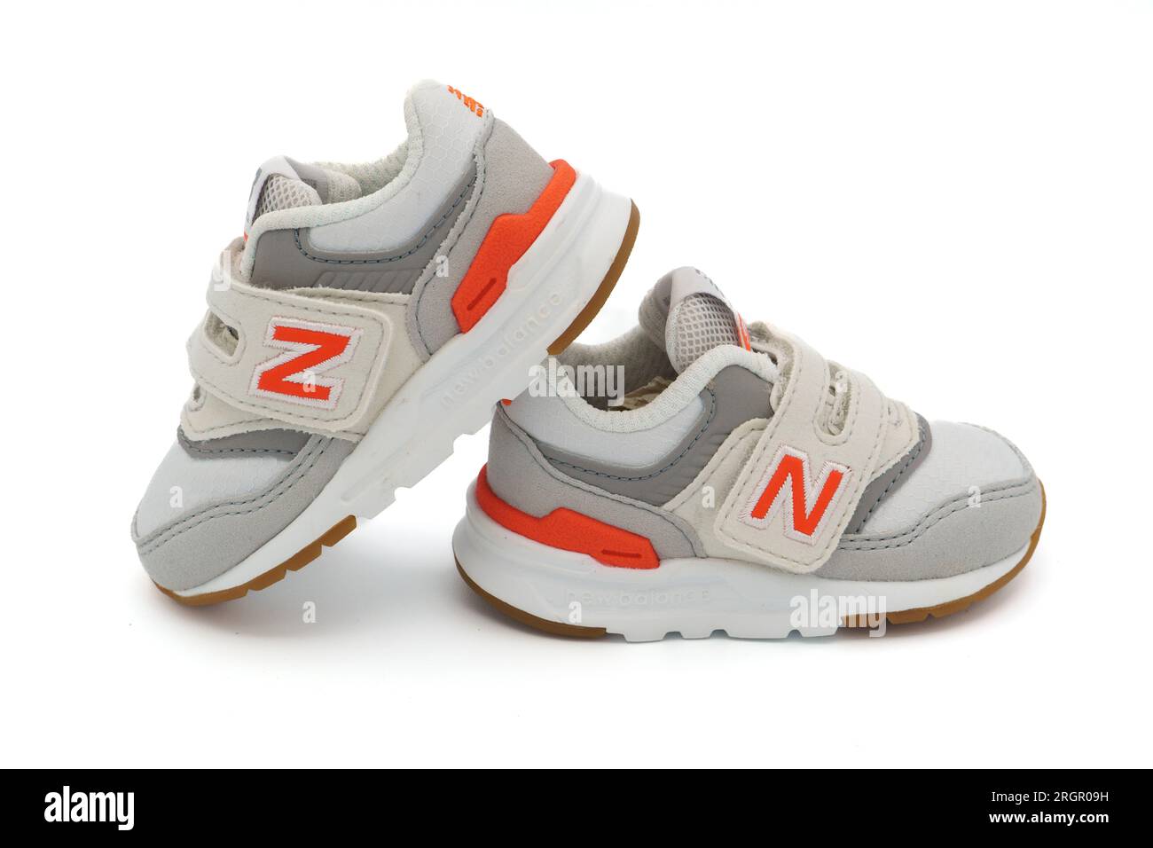 Paar weiße, winzige New Balance 997H Sneakers für Babys, die isoliert auf weißem Hintergrund ausgeschnitten sind Stockfoto