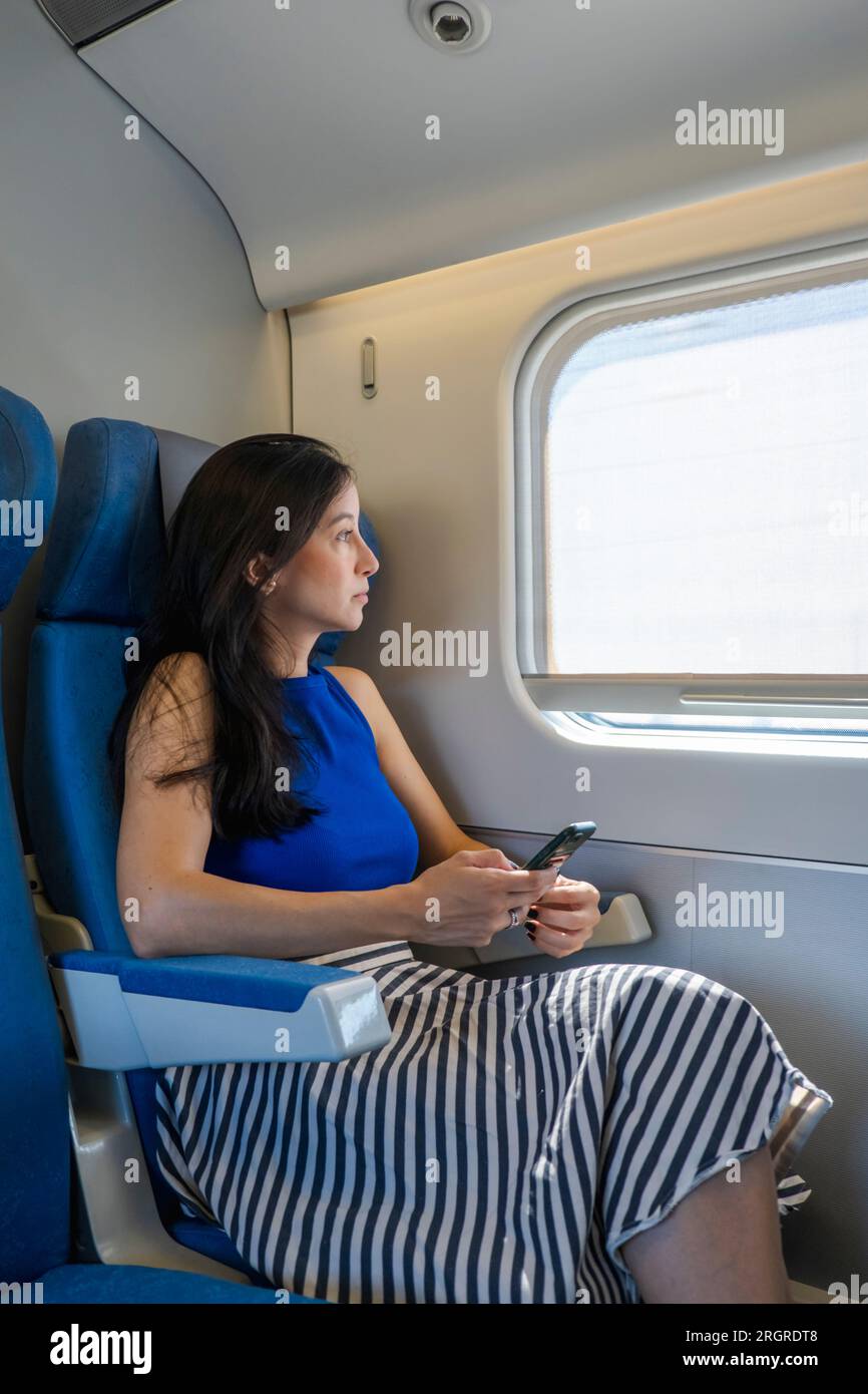 Porträt einer jungen, entspannten, schönen Frau, die mit dem Zug reist Stockfoto
