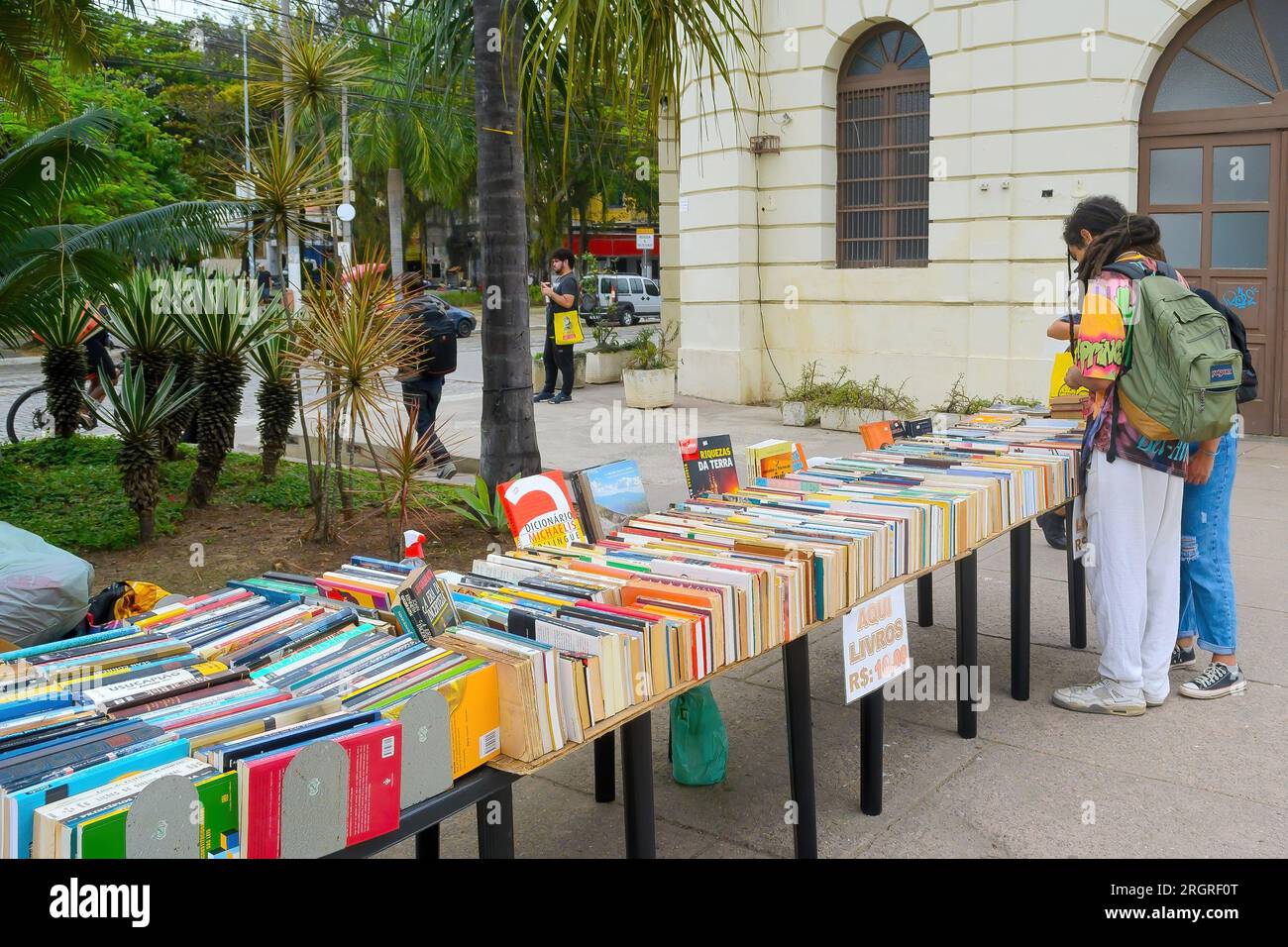 Niteroi, Brasilien, zwei Leute durchsuchen eine Gruppe gebrauchter Bücher, die in einer Stadtstraße verkauft werden. Stockfoto