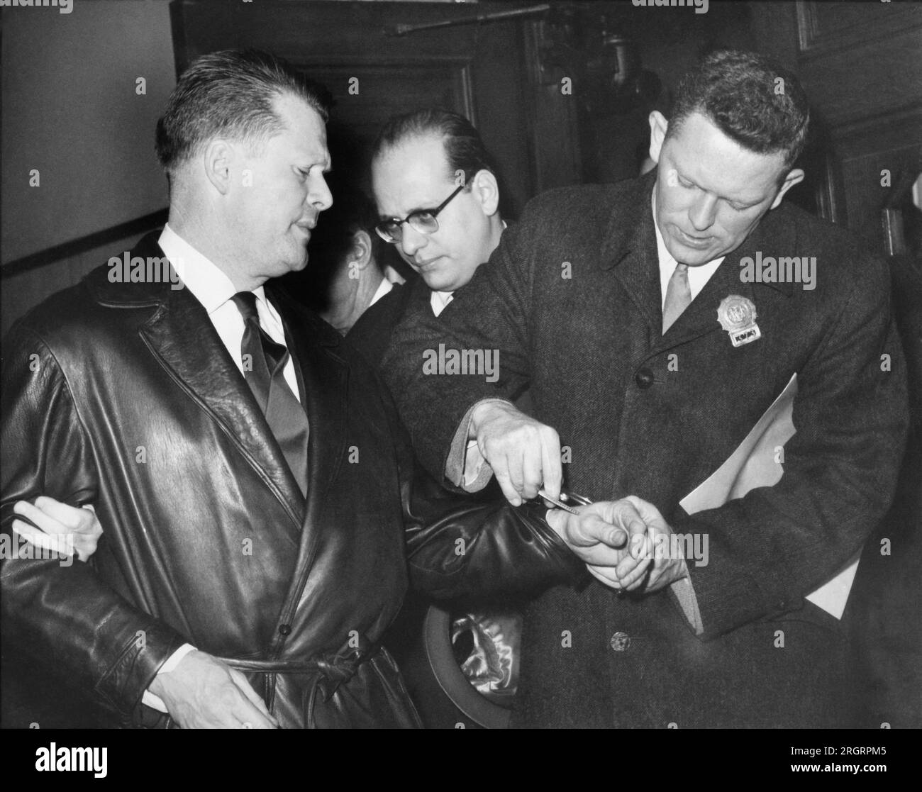 New York, New York: April 1962 Ein New Yorker Polizist legt Jimmy Hoffa während einer seiner Verhaftungen Handschellen an. Stockfoto