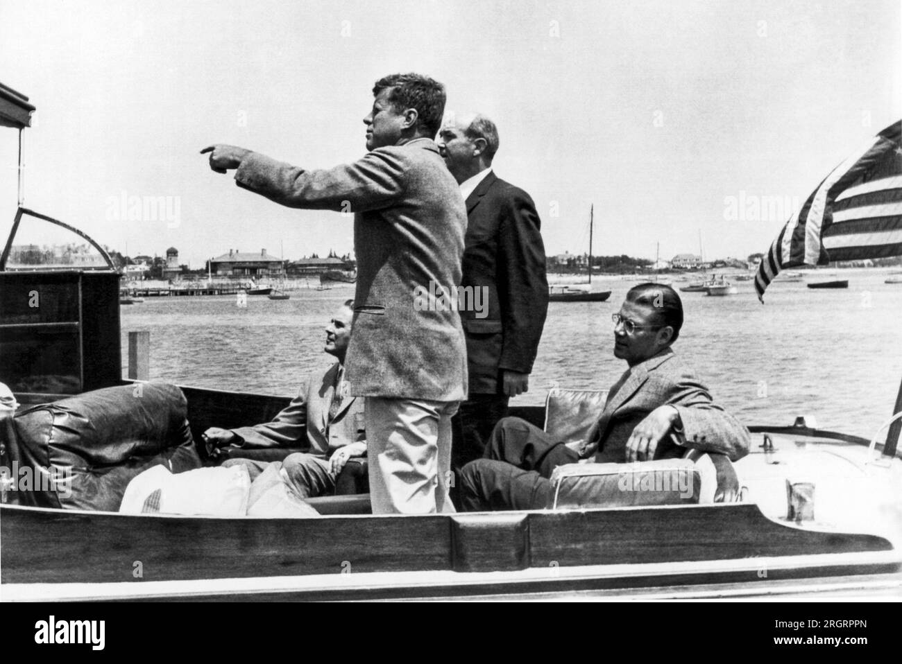 Hyannis Port, Massachusetts: 8. Juli 1961 Präsident Kennedy weist General Maxwell Taylor, Außenminister Dean Rusk, und Verteidigungsminister Robert McNamara an Bord der Yacht „Marlin“, wo Gespräche über Berlin und Deutschland stattfanden, auf die Wahrzeichen des Hyannis Port hin. Stockfoto