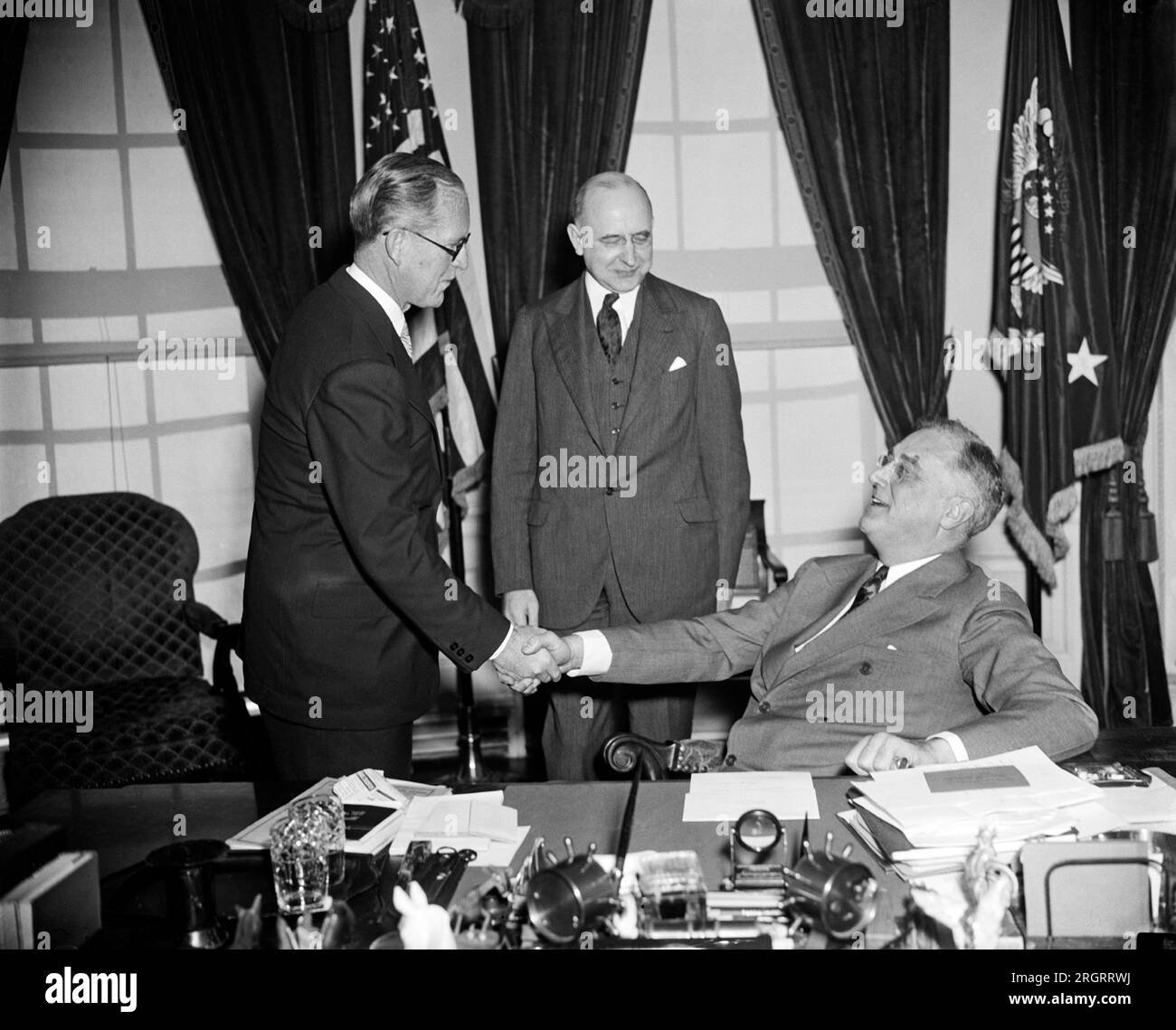 Washington, D.C.: 18. Februar 1938 Präsident Roosevelt gratuliert Joseph P. Kennedy, nachdem er den Eid von Associate Justice Stanley Reed als neuen US-Gesandten für Großbritannien abgelegt hatte. Stockfoto