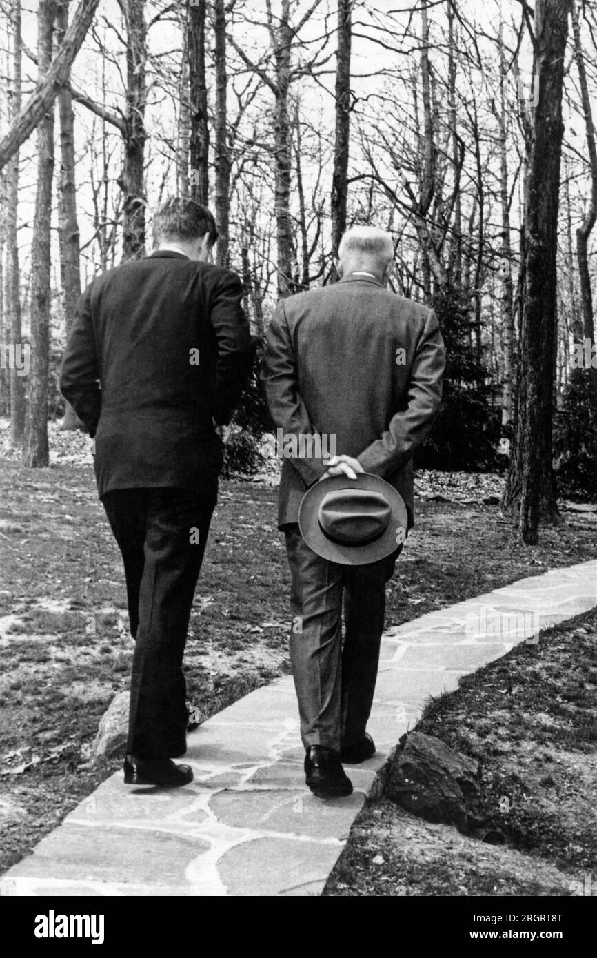 Camp David, Maryland: April 1961 Präsident John F. Kennedy geht mit dem ehemaligen Präsidenten Dwight Eisenhower einen Steinweg entlang, während er über die Frage der Invasion der Schweinebucht in Kuba nachdenkt. Dieses Foto war von Paul Vathis und wurde mit dem Pulitzer-Preis ausgezeichnet. Stockfoto