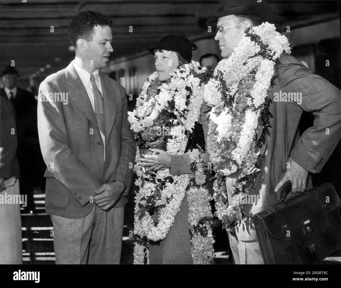 Honolulu, Hawaii: 27. Dezember 1934. Amelia Earhart und ihr Mann George Putnam werden von LT. Johnson vom Marineflotte-Luftwaffenstützpunkt begrüßt. Stockfoto