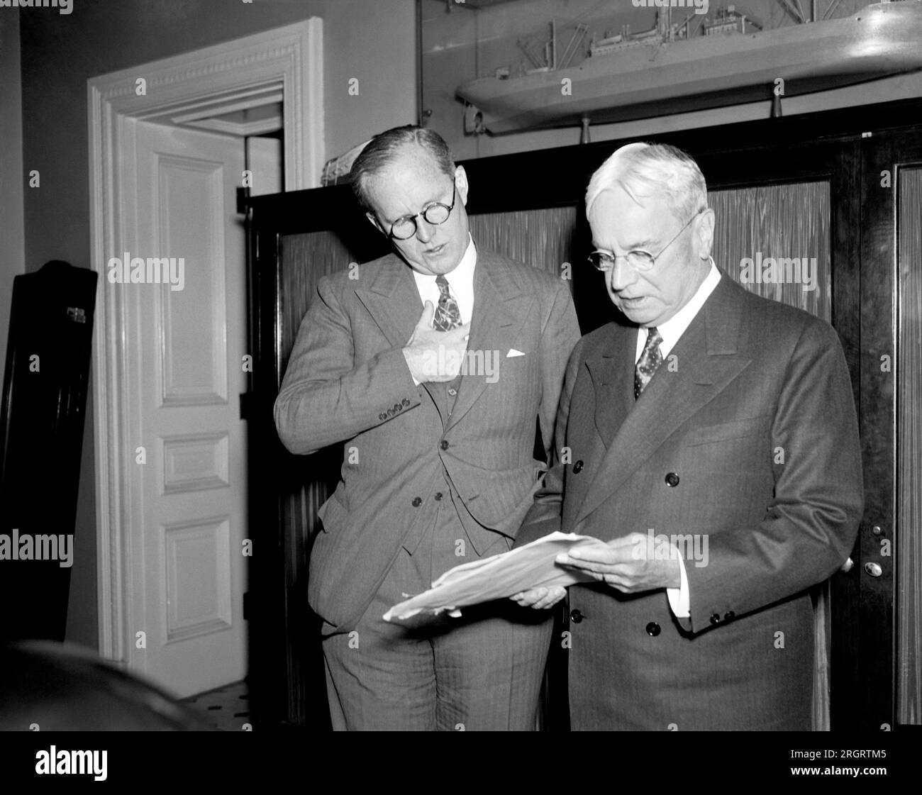 Washington, D.C.: Am 26. Januar 1938 erklärte der US-Seeschifffahrtskommissar Joseph P. Kennedy, der heute vor den Arbeits- und Handelskomitees des Senats erscheint, dass die gewerkschaftliche Opposition seine Überzeugung, dass eine neue Methode für die Bewältigung von Problemen im Seeverkehr notwendig sei, nicht erschüttert habe. Die Bundesbehörde wird bei jeder neuen Entwicklung im amerikanischen Schiffbau Hilfe benötigen, sagte Kennedy dem Komitee ebenfalls. Er wird mit Senator Hiram W. Johnson, Republikaner von Kalifornien und Mitglied des Komitees gezeigt. Stockfoto