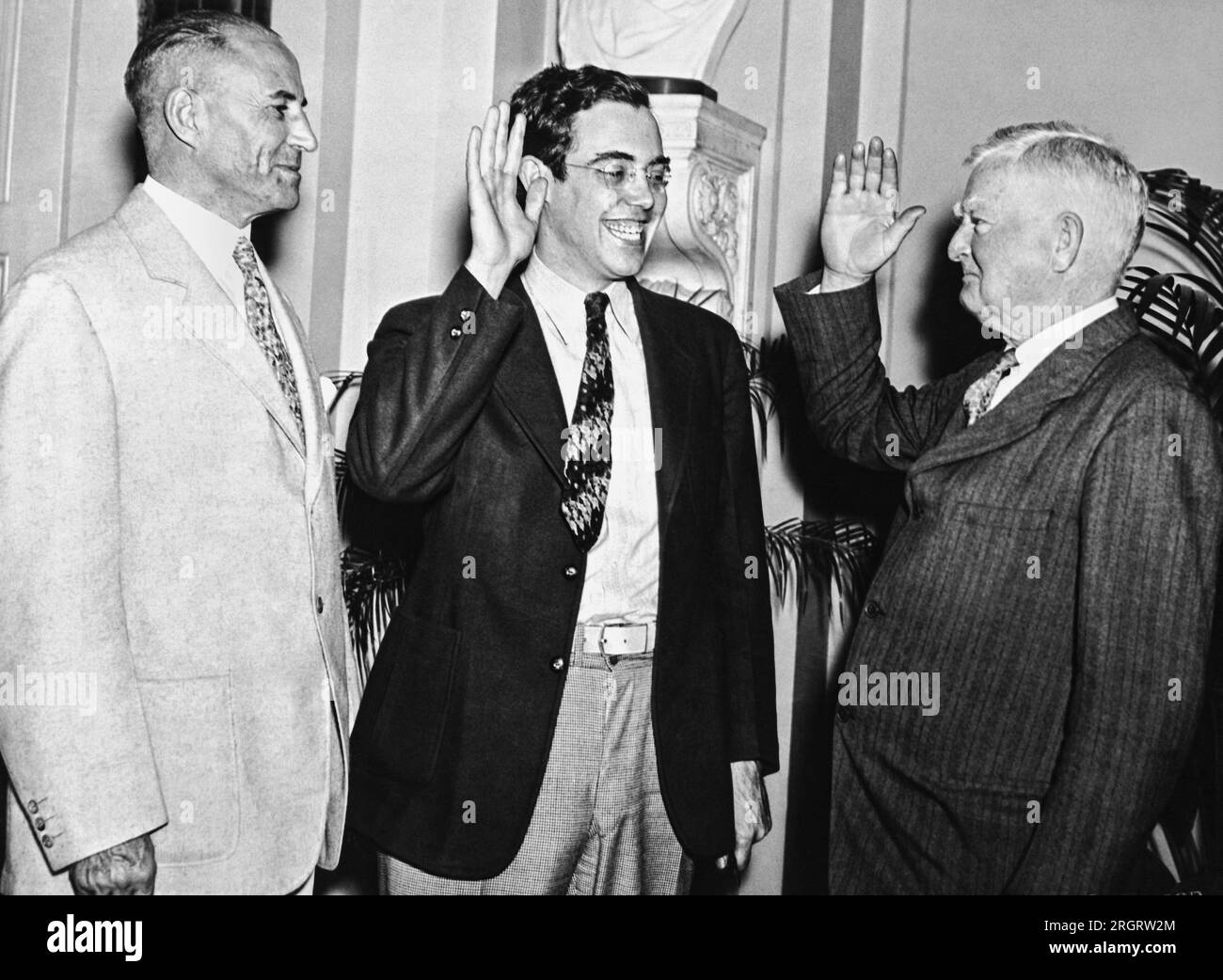Washington, D.C.: 21. Juni 1935 Vizepräsident John Garner schwört, dass Rush holt seinen Sitz im Senat einnimmt. Obwohl holt letzten November in West Virginia gewählt wurde, musste er bis Juni 19. warten, als er das erforderliche Alter von 30 Jahren wechselte, um seinen Sitz im Senat einnehmen zu können. Senatorin M. Neeley aus West Virginia steht auf der linken Seite bereit. Stockfoto