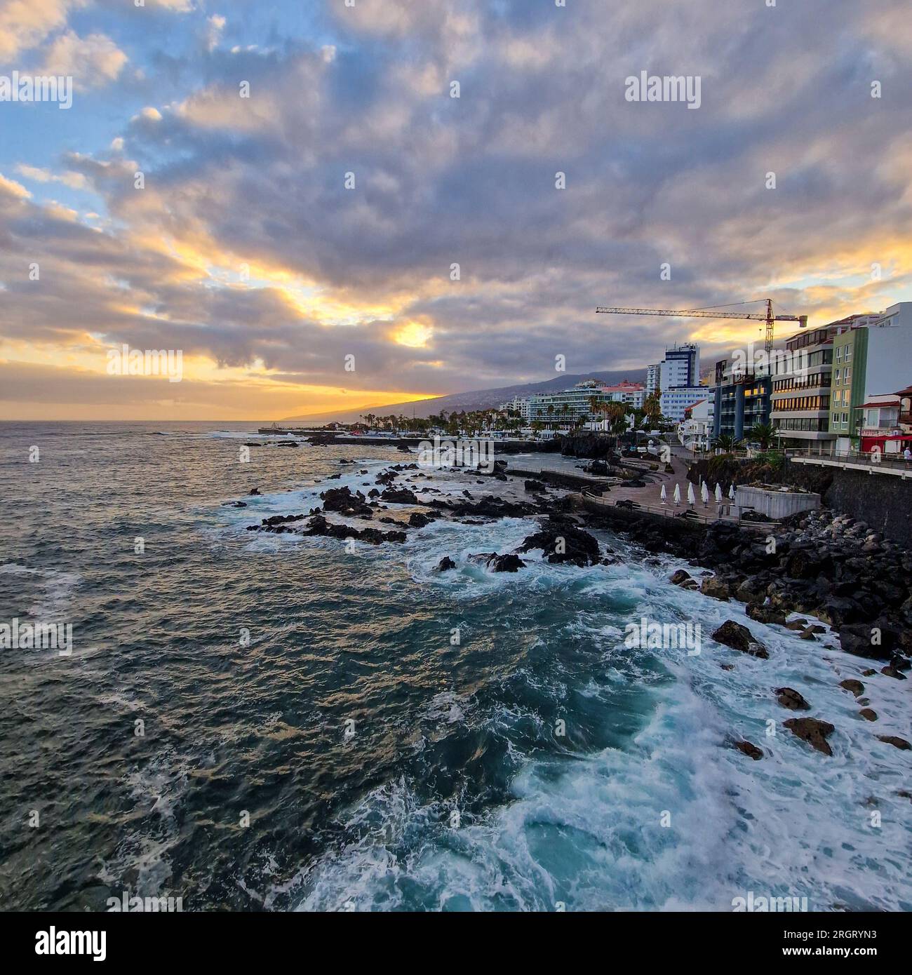 Bei Sonnenaufgang erwacht Puerto de la Cruz mit der sanften Umarmung der Morgensonne. Die Stadt, immer noch in den Überresten der Nacht eingewickelt, beginnt zu schwingen Stockfoto