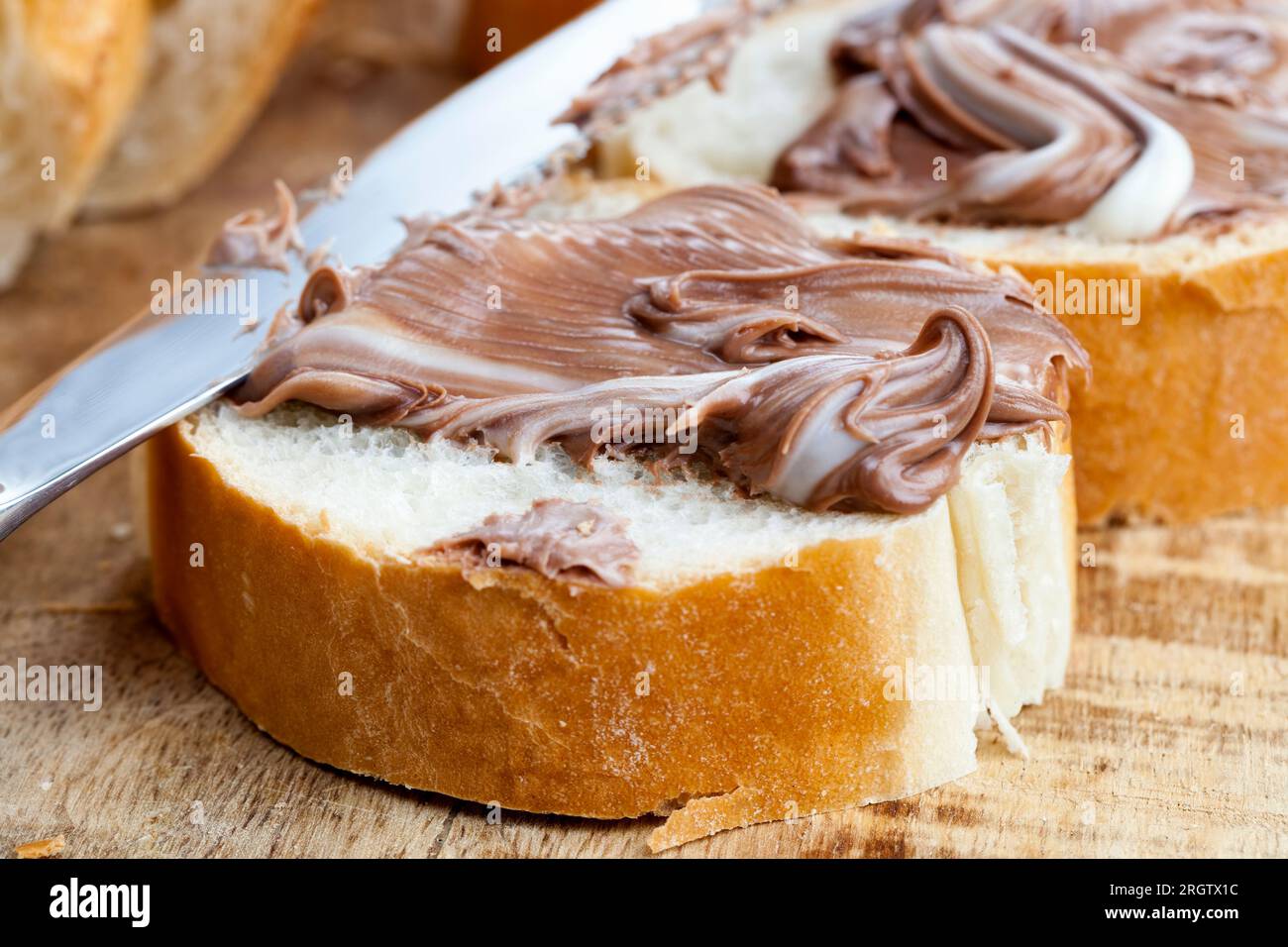 Weißbrotscheiben mit süßer Schokoladenbutter, weicher Schokoladenbutter und Weißbrot, natürliche Kakao-Schokoladenpaste während des Frühstücks Stockfoto