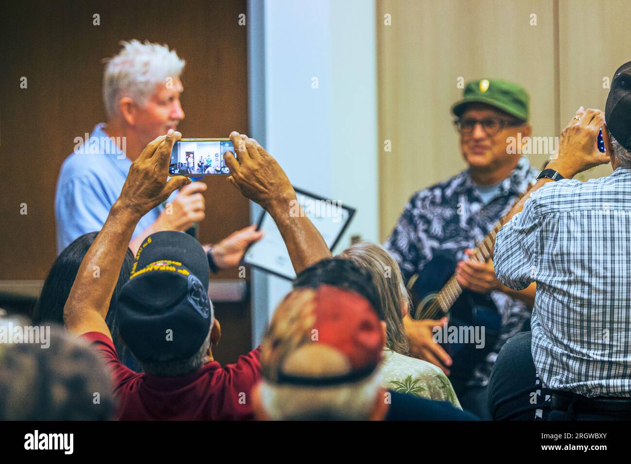 Ein ehrliches Bild eines Gastes, der einen besonderen Moment mit seinem Telefon bei der Guitars for Vets Graduation in der Loma Linda VA Clinic im August 2023 festhält Stockfoto