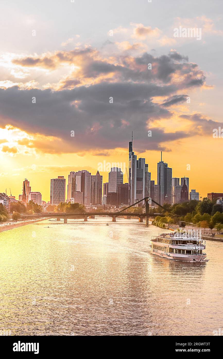 Blick auf Frankfurt bei Sonnenuntergang. Aufnahme mit Hintergrundbeleuchtung und Blick auf die Skyline. Hochhäuser von Banken und Versicherungsgesellschaften im Finanzdistrikt Stockfoto