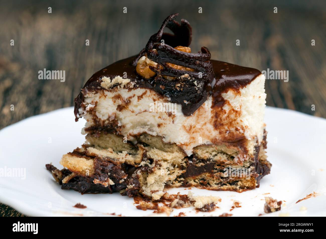 Schokoladencreme-überzogener Cremetorte mit Biskuitkuchen, würfelförmiger Kuchen auf einem Teller Stockfoto