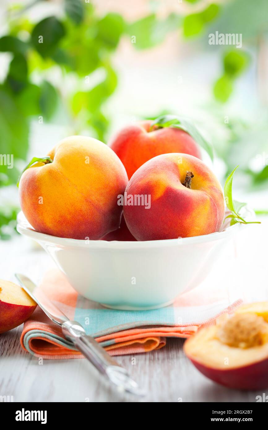 Schüssel mit frischen Pfirsichen auf dem Tisch Stockfoto