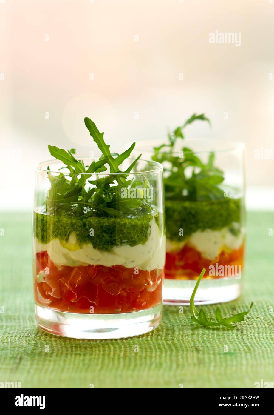 Vorspeise mit Tomaten, Käse und Pesto in Gläsern Stockfoto