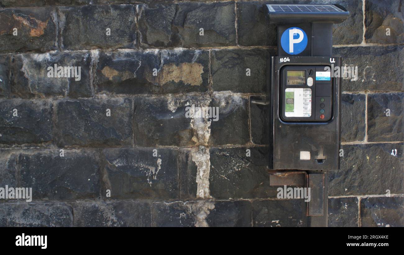 Parkautomat neben einer alten Steinmauer. Irland, Dublin 06.06.2023. Stockfoto