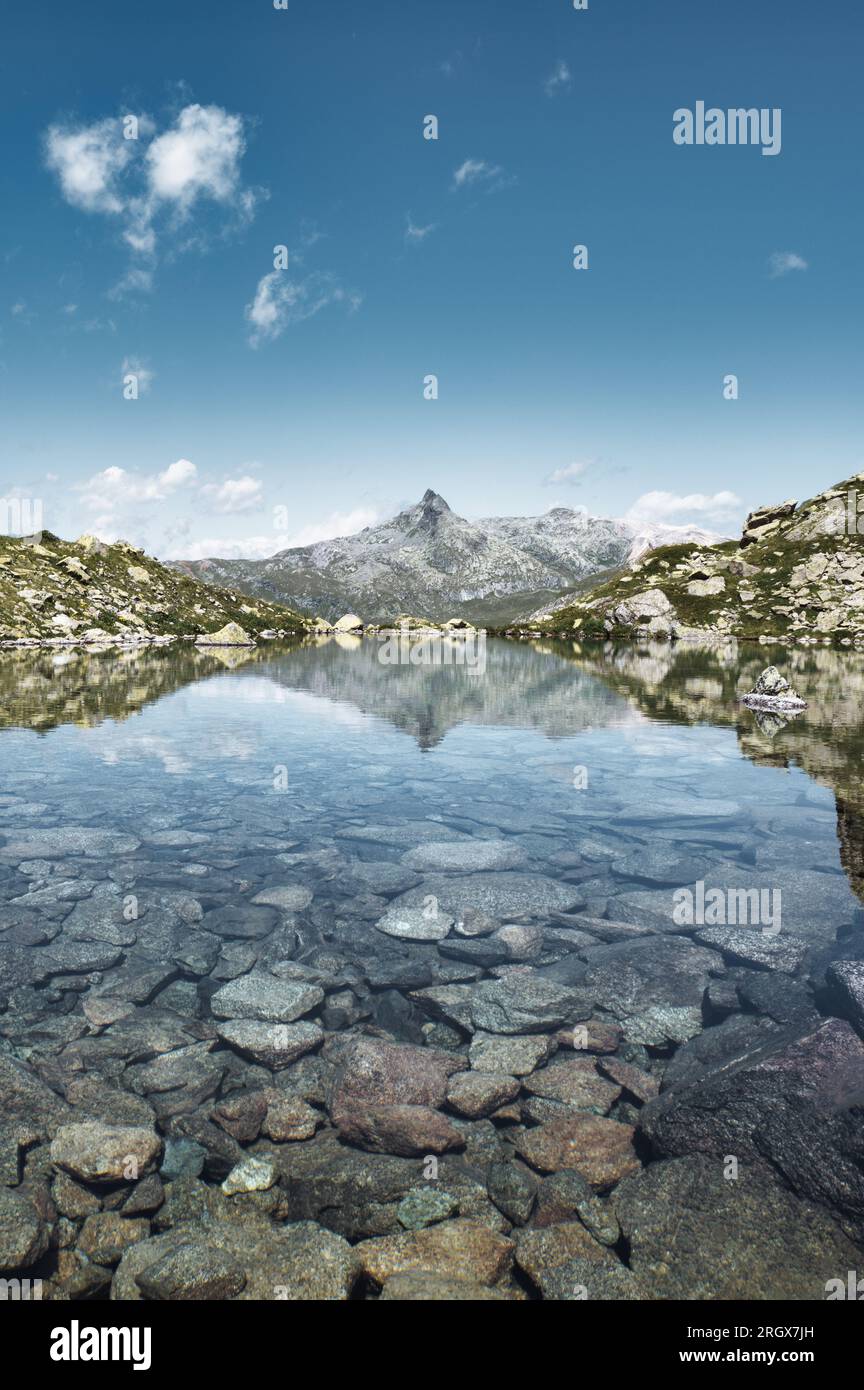 Kleiner Bergsee mit klarem Wasser und Steinen auf dem Grund Stockfoto