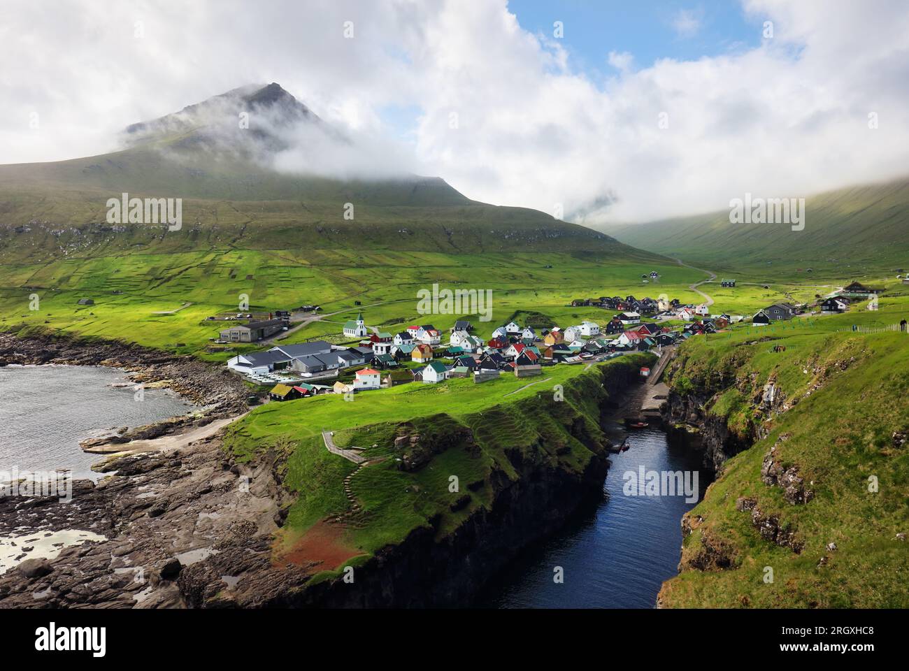 Dorf Gjogv auf den Färöern mit bunten Häusern. Berglandschaft mit Meeresküste Stockfoto
