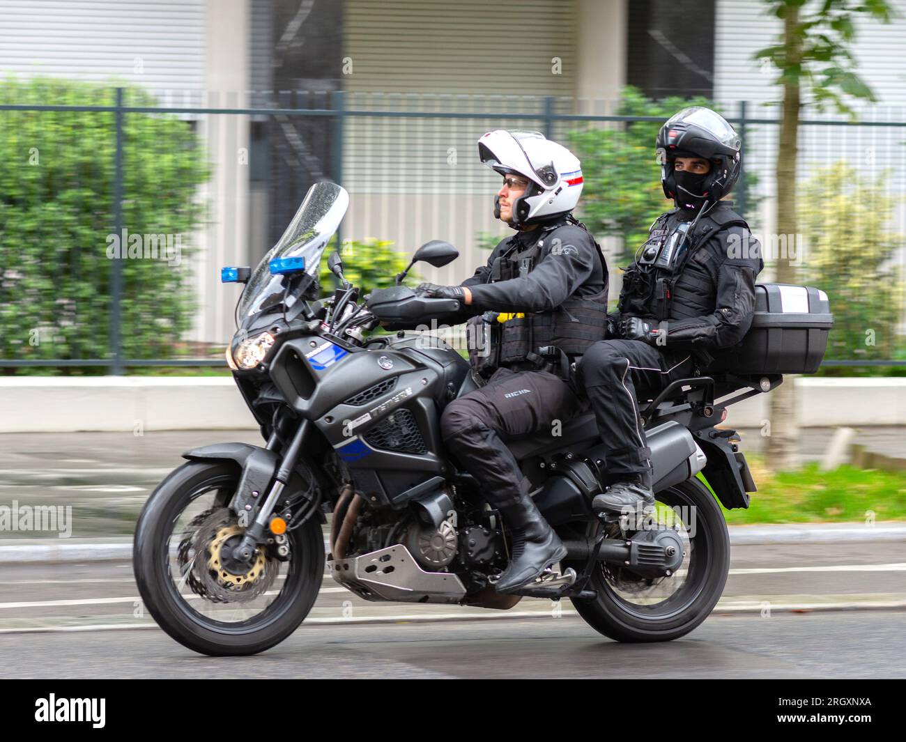 Unmarkiertes Polizeimotorrad mit zwei Polizisten in der City Center Street - Paris 16, Frankreich. Stockfoto
