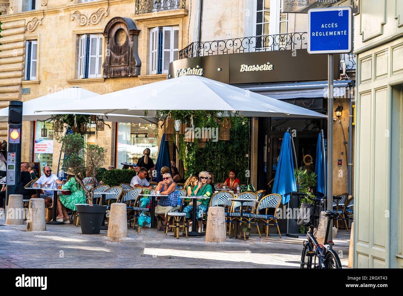 Aix-en-Provence, Frankreich -- 12. August 2023. Leute in einem Straßencafé in Aix-en-Provence. Stockfoto