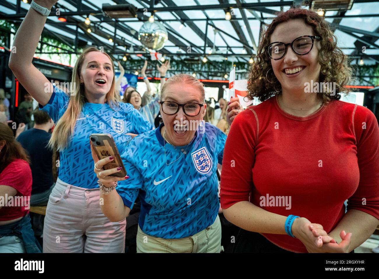 London, Großbritannien. 12. August 2023. Englische Fans im BOXPARK in Shoreditch feiern den Sieg nach der Live-Übertragung des englischen Viertelfinalspiels gegen Kolumbien bei der FIFA Women's World Cup 2023, die in Australien und Neuseeland stattfindet. Endstand 2:1. Kredit: Stephen Chung / Alamy Live News Stockfoto