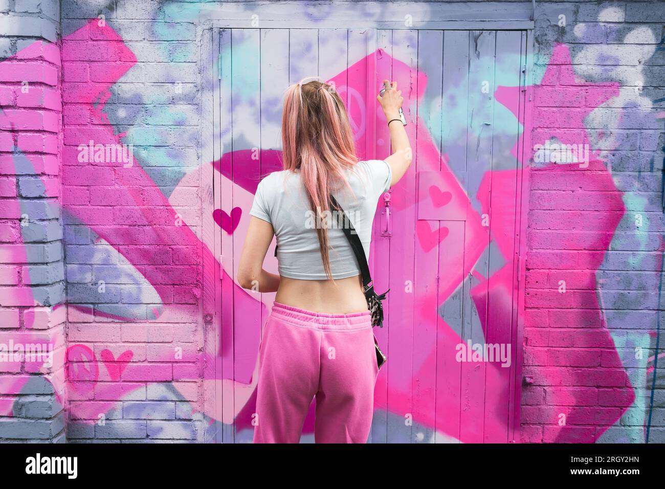 Birmingham, Großbritannien. 12. Aug. 2023. Die Graffiti-Künstlerin „DOLZ“ trägt Barbie Rosa auf ironischere Weise, wenn sie im Digbeth District in Birmingham, Großbritannien, im Rahmen des High Vis Street Art Festivals an verfallenen Wänden arbeitet. Dutzende von Straßengurffiti-Sprays können jedes Jahr in der Stadt ihre Spuren hinterlassen. Kredit: Peter Lopeman/Alamy Live News Stockfoto Birmingham, Großbritannien. 12. Aug. 2023. Die Graffiti-Künstlerin „DOLZ“ trägt Barbie Rosa auf ironischere Weise, wenn sie im Digbeth District in Birmingham, Großbritannien, im Rahmen des High Vis Street Art Festivals an verfallenen Wänden arbeitet. Dutzende von Straßengurffiti-Sprays können jedes Jahr in der Stadt ihre Spuren hinterlassen. Kredit: Peter Lopeman/Alamy Live News Stockfoto