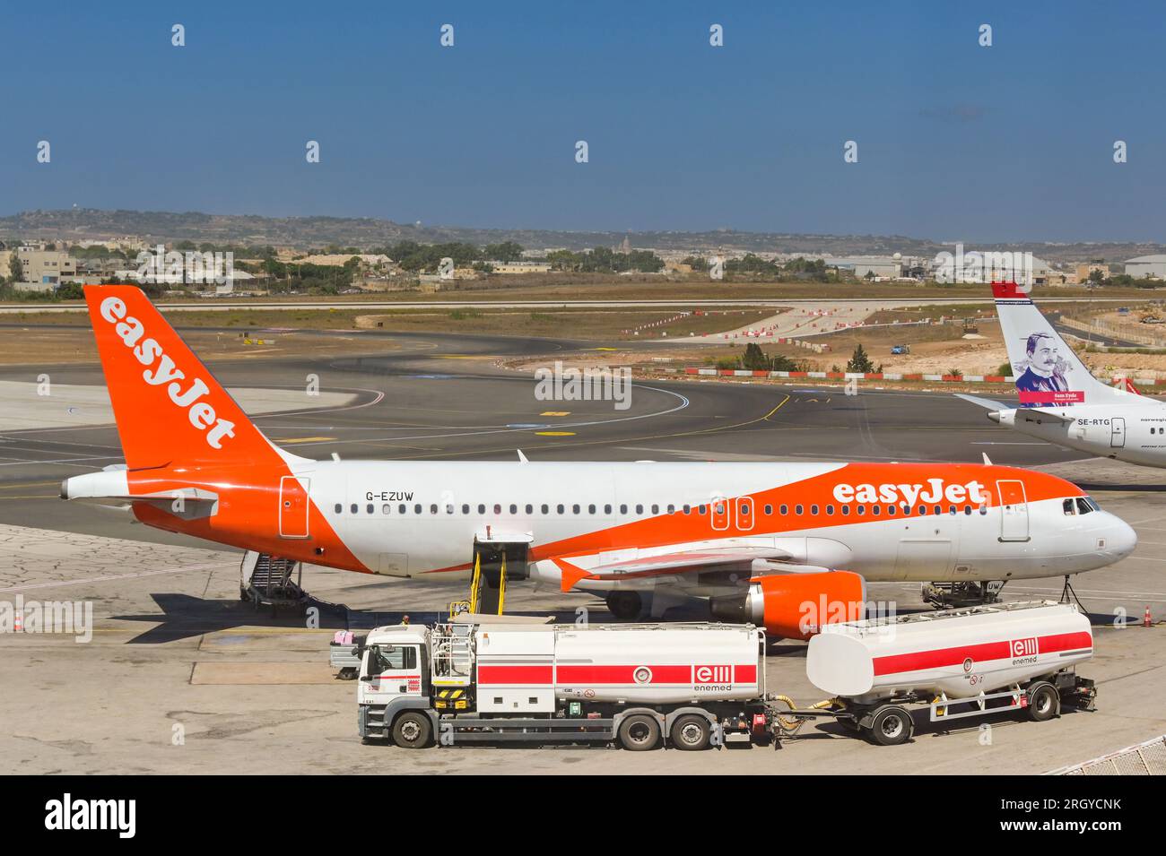 Luqa, Malta - 7. August 2023: Urlaubsjet Airbus A320 am Boden des Internationalen Flughafens Malta mit Tankschiff daneben Stockfoto