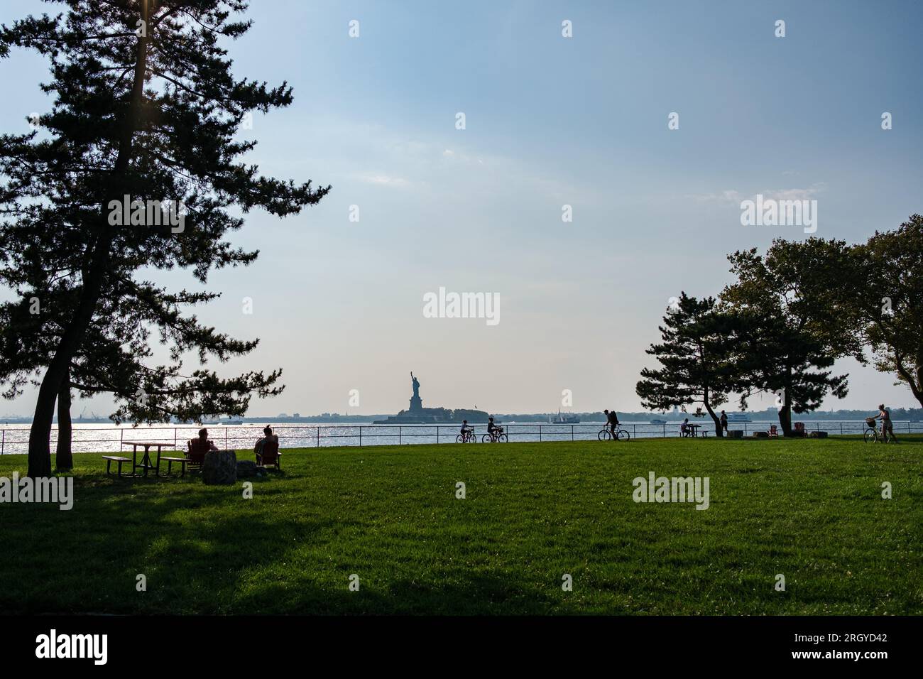 Ruhiger Augustnachmittag im Governor's Island Park, mit der Freiheitsstatue in der Ferne Stockfoto