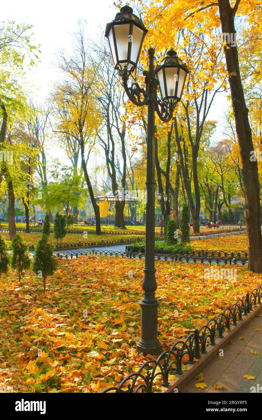 Das Bild zeigt den Herbstpark in der Stadt Odessa. Im Vordergrund eine Straßenbeleuchtung. Stockfoto