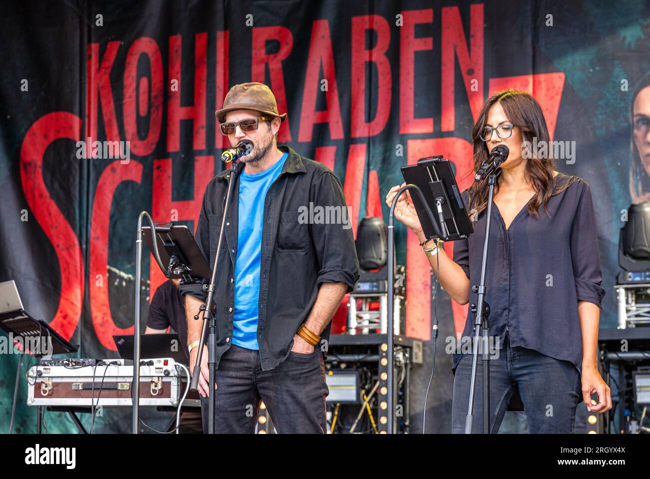 Cottbus, Deutschland. 12. Aug. 2023. Schauspieler Peter Ketnath und Schauspielerin Bettina Zimmermann sind auf der Bühne des Elbenwald Festivals für eine Live-Folge des Radioauftritts Kohlrabenschwarz. Das Elbenwald Festival ist ein dreitägiges Treffen für Menschen jeden Alters, die Filme, Fantasie, Spiele, Konzerte und eine beliebige Kombination von allem genießen. Die Organisatoren erwarten etwa 15.000 Besucher. Kredit: Frank Hammerschmidt/dpa/Alamy Live News Stockfoto