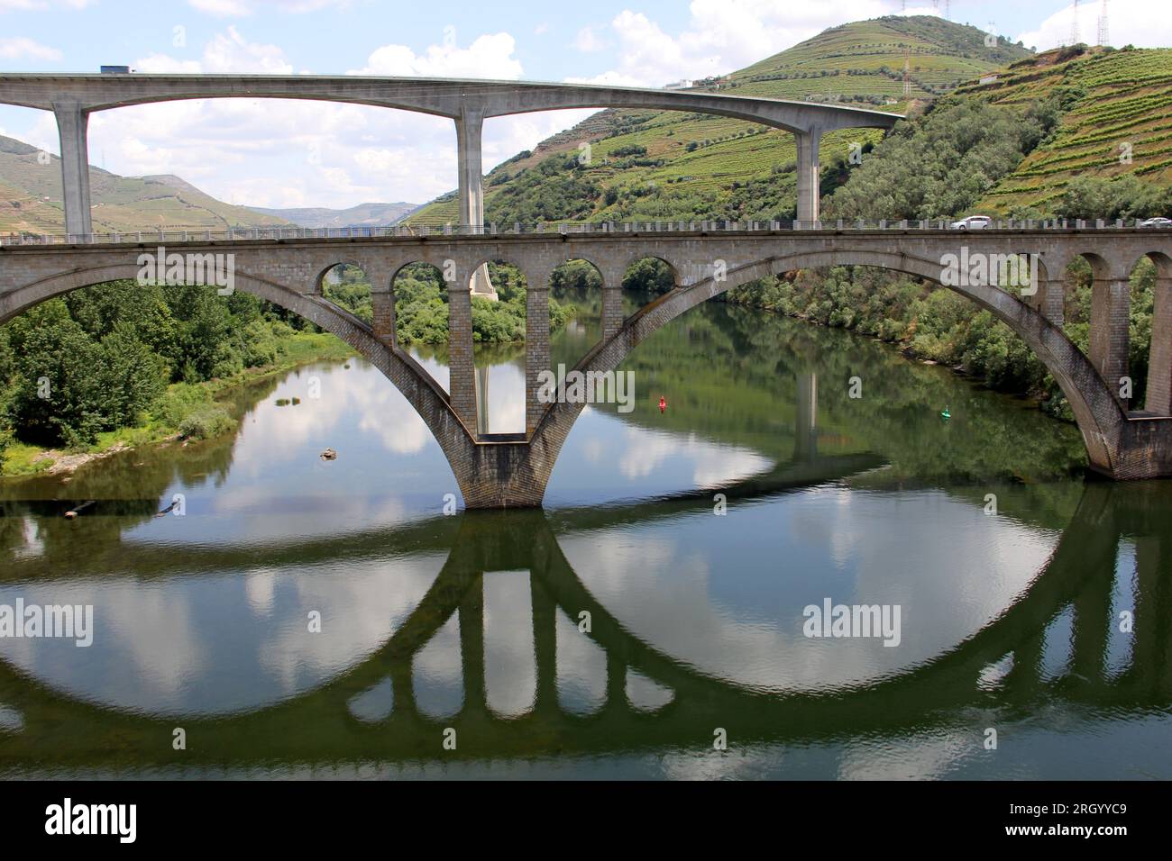 Brücken über den Douro Fluss östlich von Porto in der portugiesischen Weinregion, terrassenförmig angelegte Weinberge auf Hängen im Hintergrund, Peso da Regua, Portugal Stockfoto