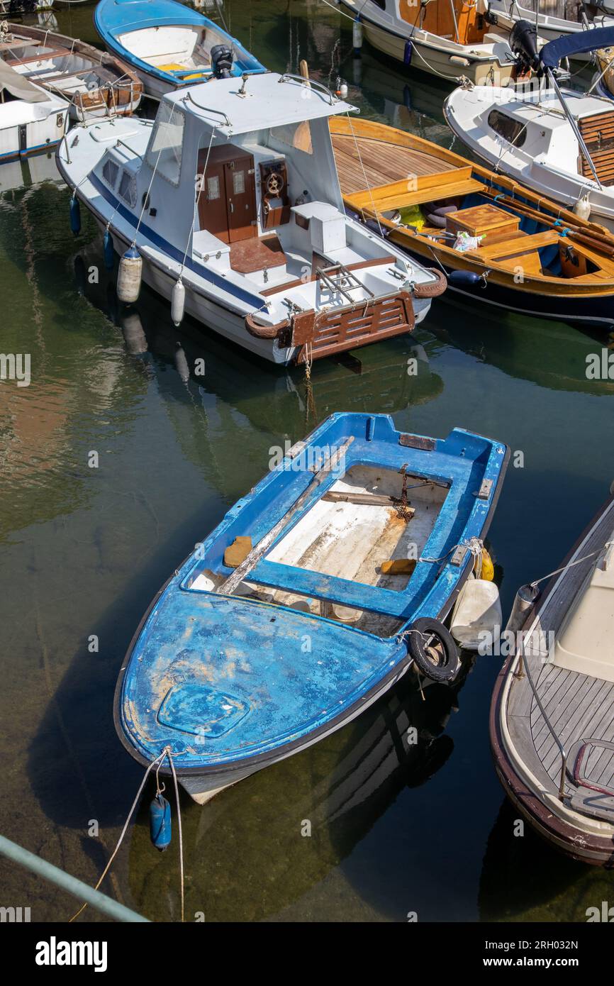 Ein altes blaues Boot in einem kleinen Hafen Stockfoto