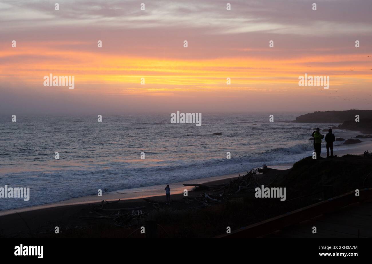 Leute, die den Sonnenuntergang am Moonstone Beach beobachten Stockfoto