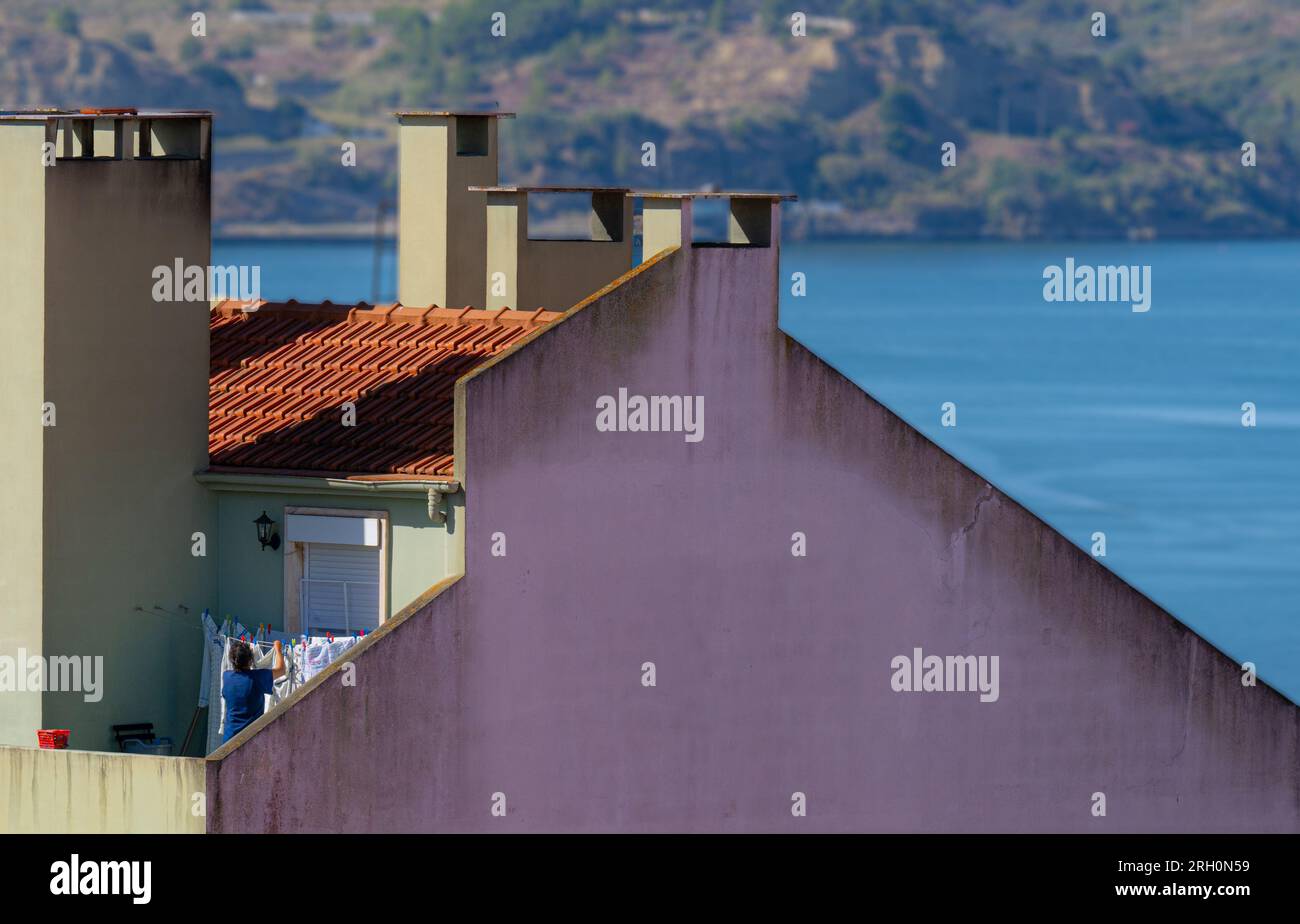Frau hängt Wäsche zum Trocknen in Lissabon, Portugal Stockfoto