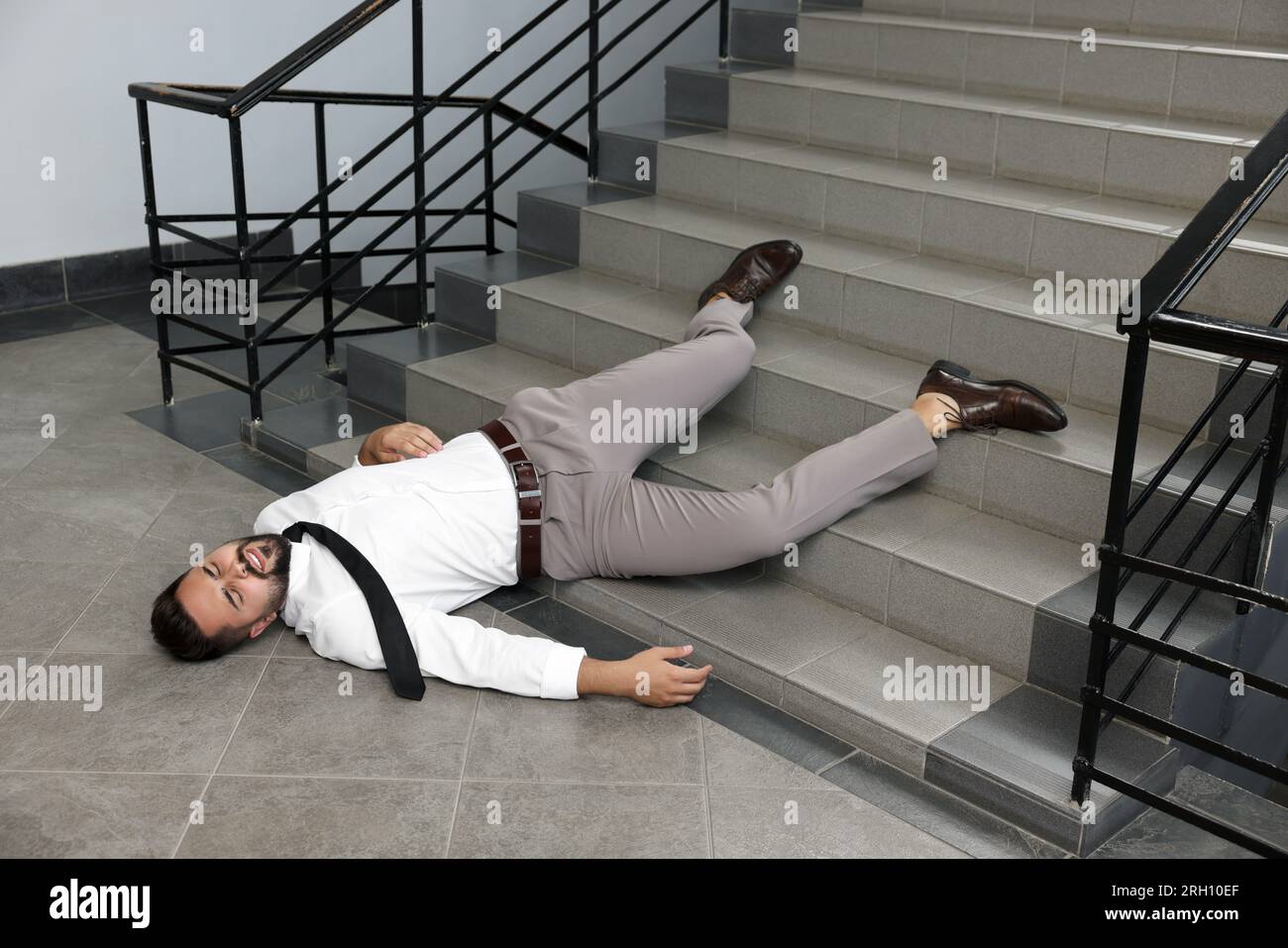 Bewusstloser Mann, der im Haus lag, nachdem er die Treppe hinuntergefallen war Stockfoto