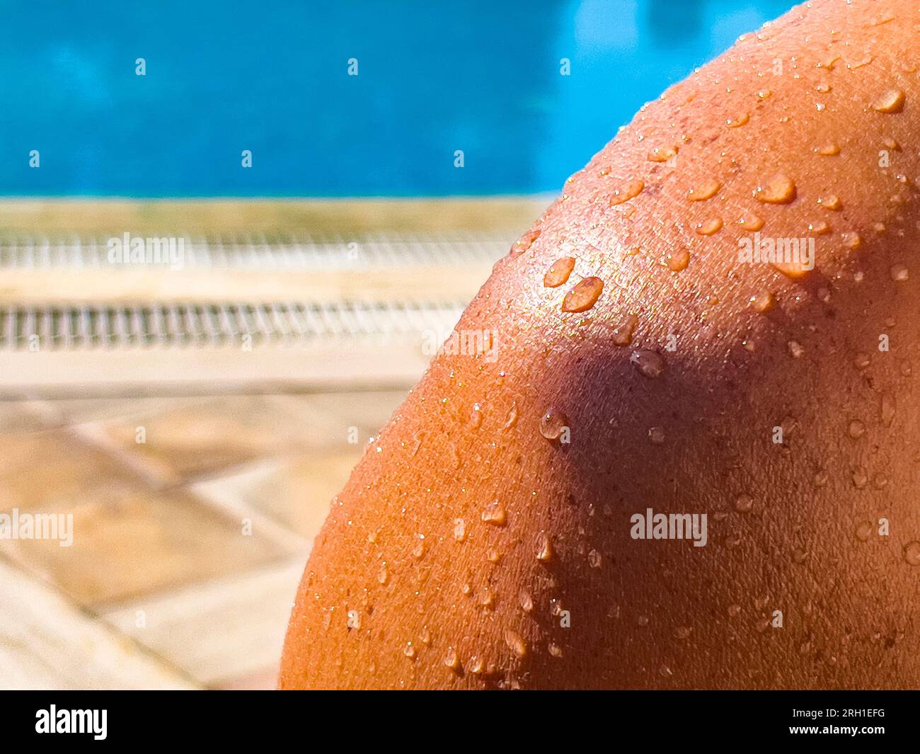 Wassertropfen auf sonnengeküsster Haut. Nahaufnahme auf nackter Schulter nach dem Schwimmen im Pool. Sommer-Reise-Hintergrund, Kopierraum. Sonnenschutz. Stockfoto
