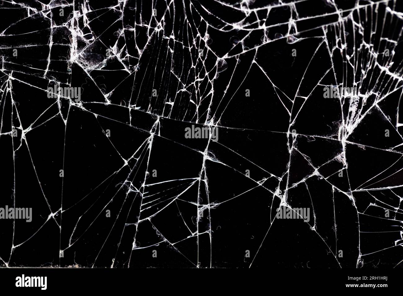 Altes schmutziges Glas mit vielen Rissen, altes zerbrochenes Glas auf schwarzem Hintergrund Stockfoto