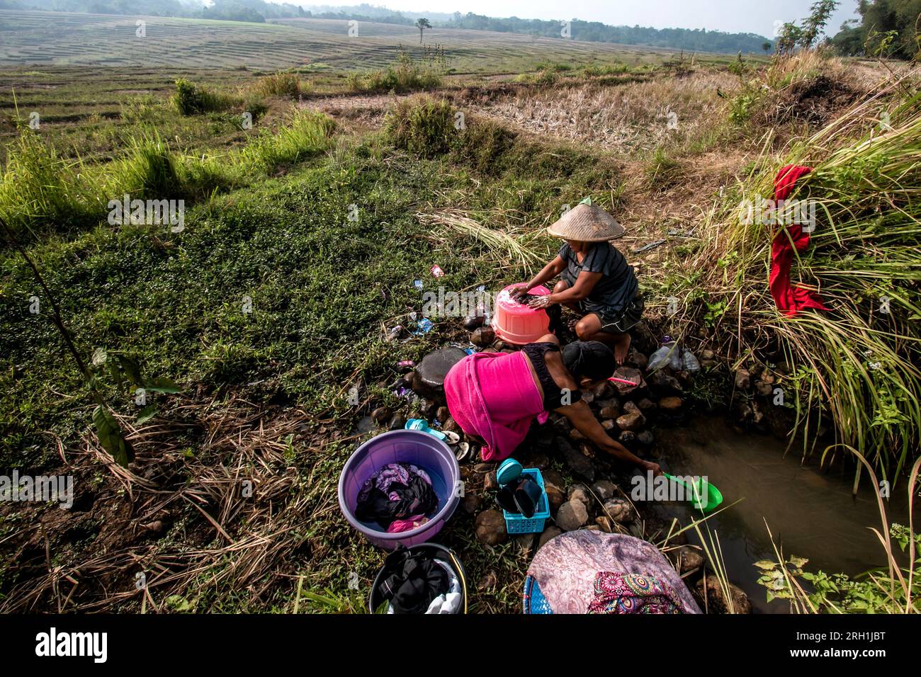 Die Bewohner in Bogor, West Java, Indonesien, waren gezwungen, Infiltrationswasser auf dem Reisfeld zu verwenden, um Kleidung zu waschen am 12. August 2023 Stockfoto