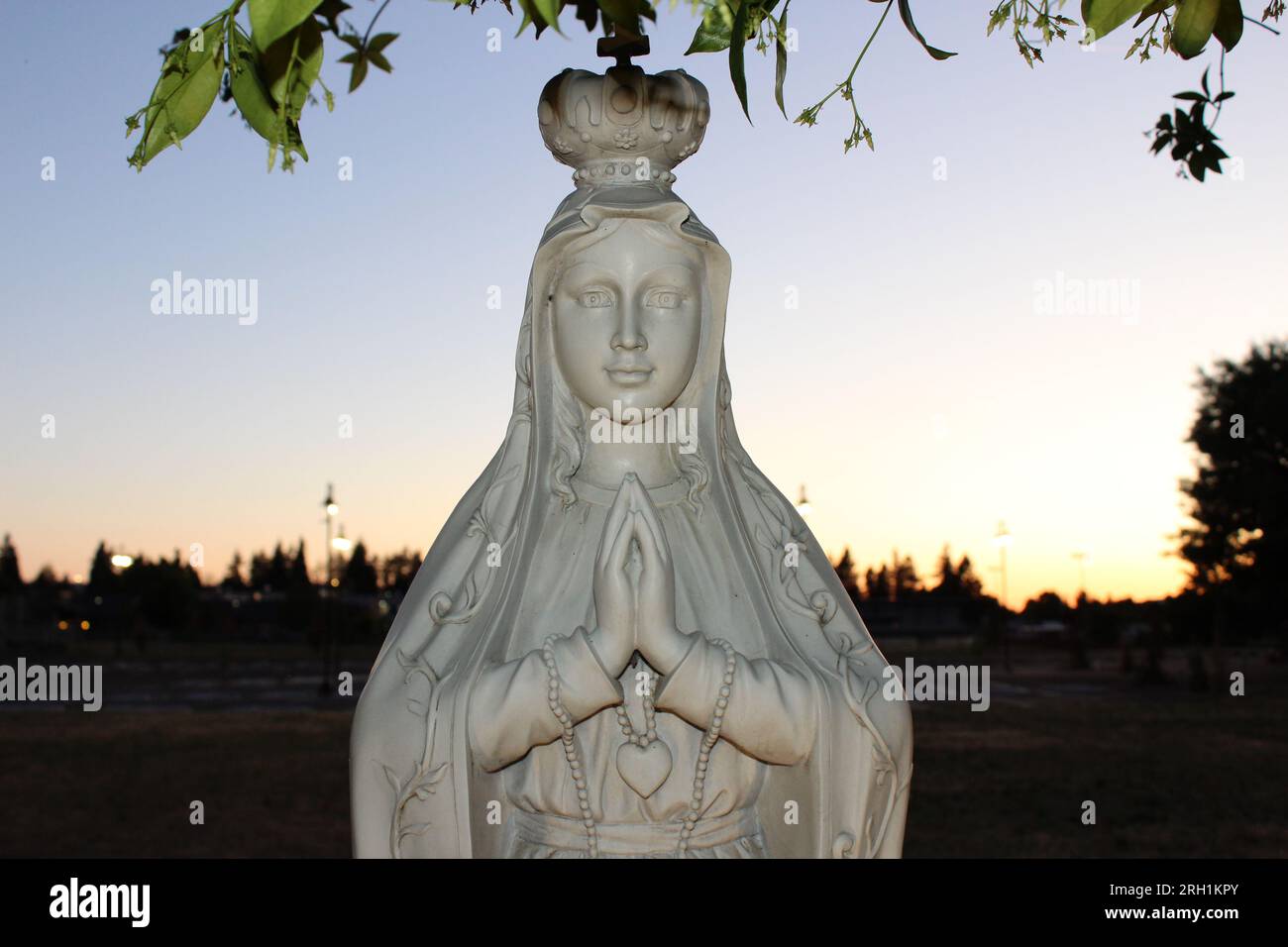 "Göttliche Ruhe, Eine fesselnde Marmorstatue einer Frau im Gebet, die ein tiefes Gefühl von Frieden und spiritueller Betrachtung hervorruft." Stockfoto