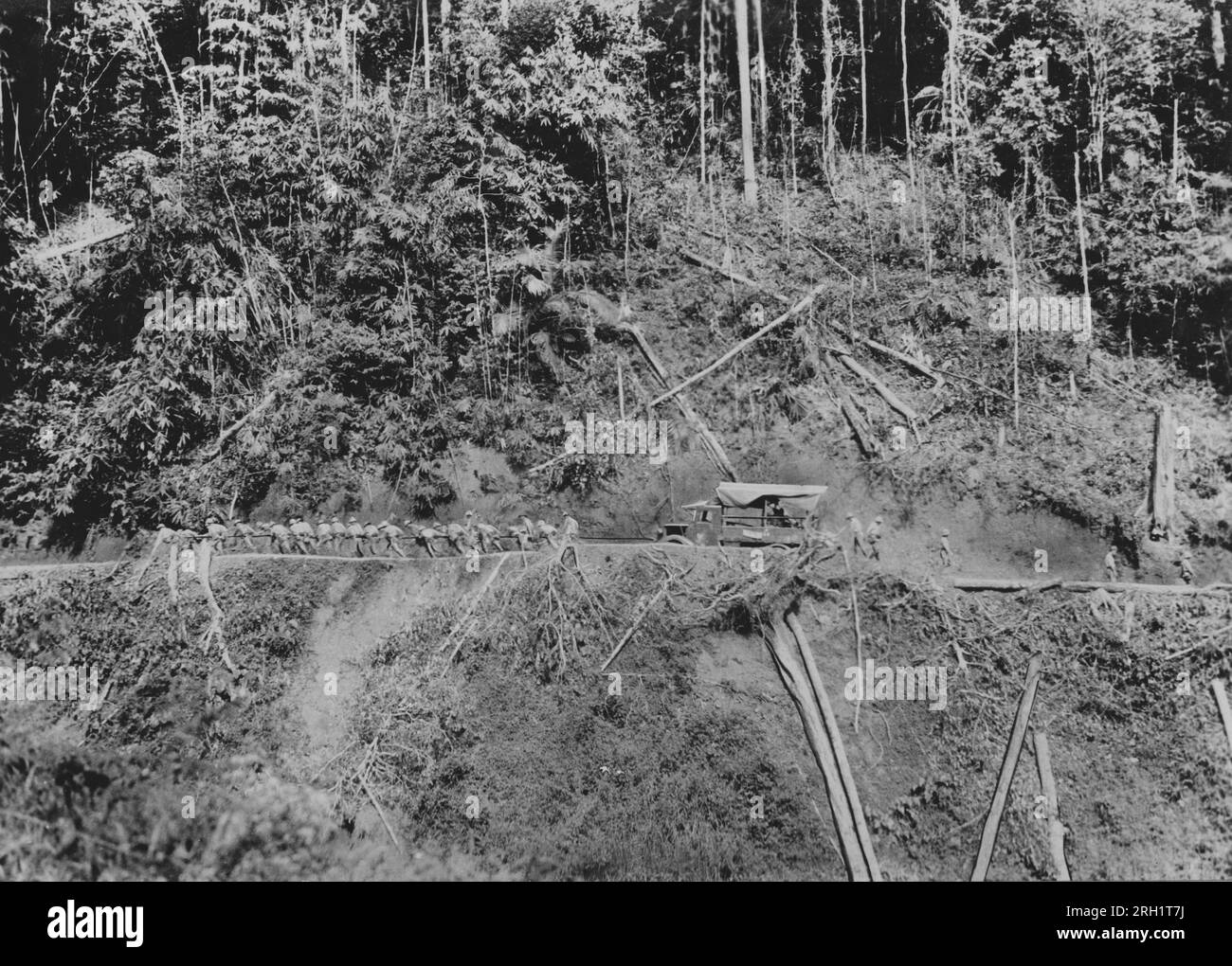 Malaya Campaign, Dezember 1941 – Februar 1942. Kaiserlich-japanische Armeetruppen des Nishimura Vehicle Corps schleppen einen ihrer LKWs manuell auf eine steile und unbefestigte Bergstraße, während sie etwa im Januar 1942 durch Malaya vorrücken. Stockfoto