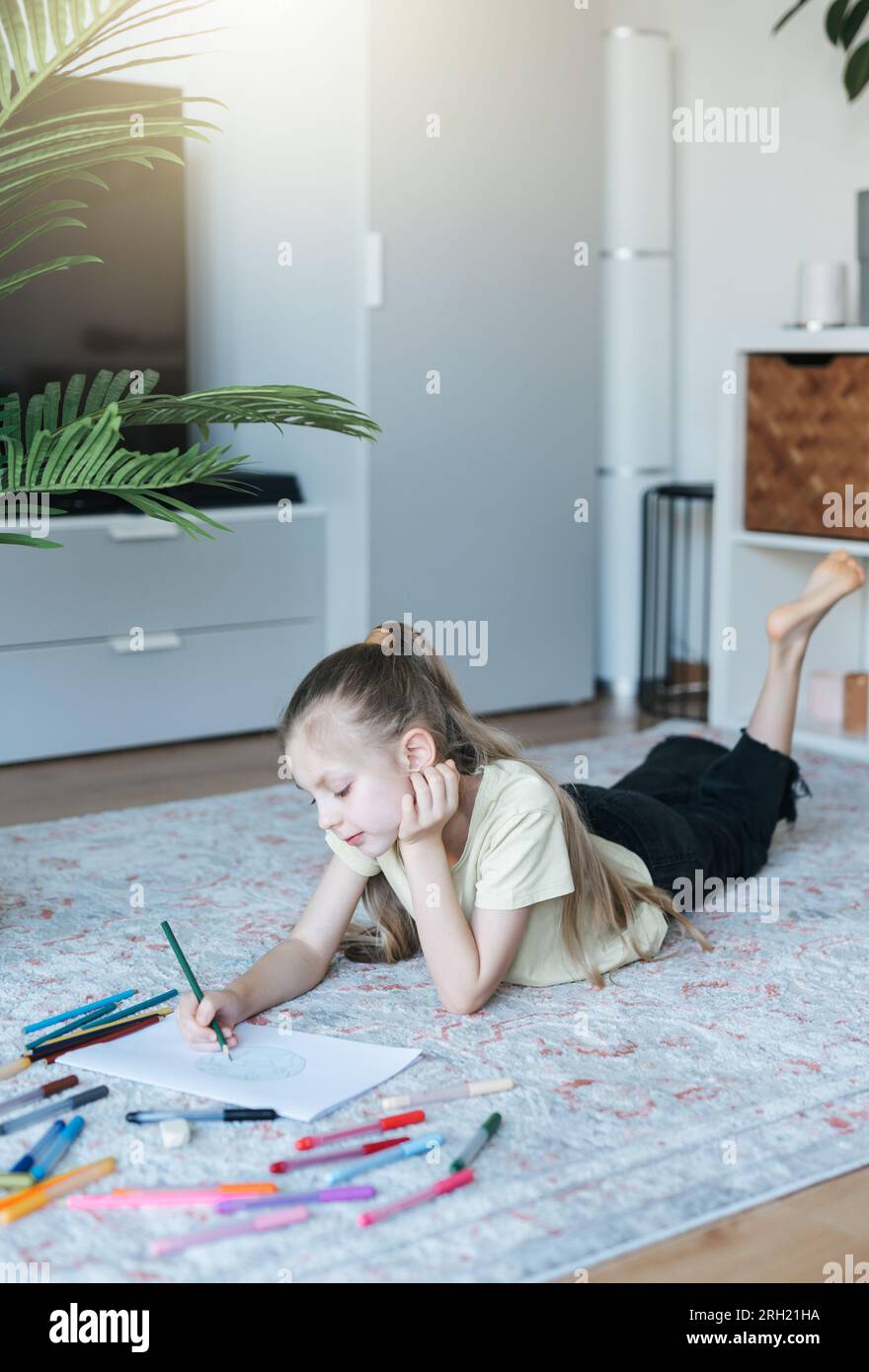 Kindermädchen malt zu Hause mit bunten Bleistiften. Ökologie-Konzept, Erde malen. Stockfoto