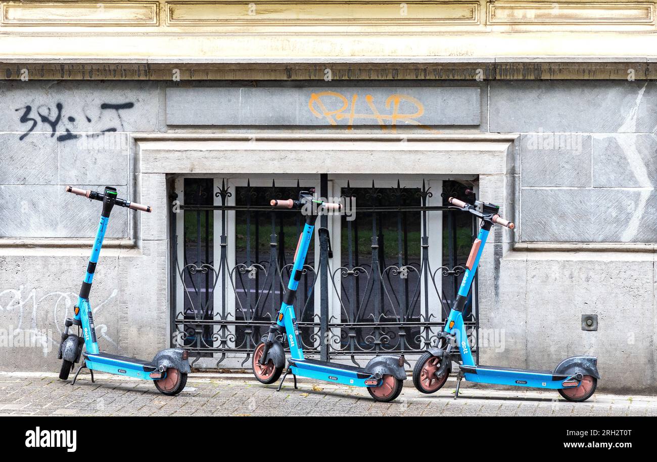 Drei selbstfahrende Elektroroller von DOTT, die auf dem Bürgersteig in der Innenstadt in Brüssel, Belgien, geparkt sind. Stockfoto