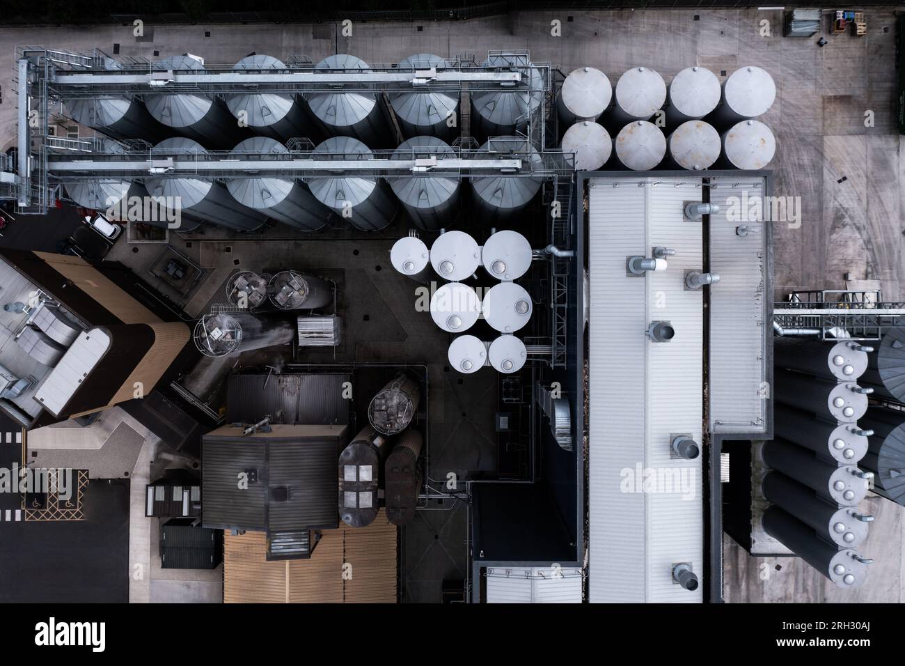 Luftaufnahme direkt über großen Lagertanks in einer Reihe für die Lebensmittelproduktion oder die Lagerung von Chemikalien in einem Industriewerk oder einer Fabrik Stockfoto