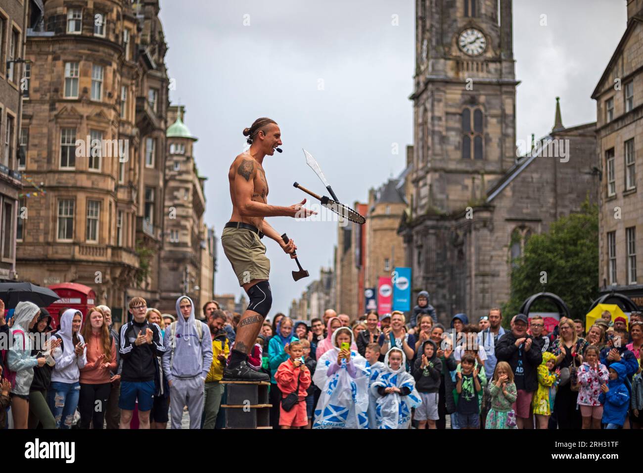 Royal Mile, Edinburgh, Schottland, Großbritannien. 13. August 2023. Die Darsteller des Edinburgh Festival Fringe erlitten heftige Regenschauer während ihrer Shows auf der High Street am zweiten Sonntag des Kunstfestivals, die Brolleys gingen hoch, wasserdichte Dächer waren an und das Publikum blieb größtenteils in der Nähe. Abbildung: Street Performer Reidiculous demonstriert Peitschen und Jonglieren vor einem sehr feuchten Publikum in der High Street. Kredit: Archwhite/alamy Live News. Stockfoto