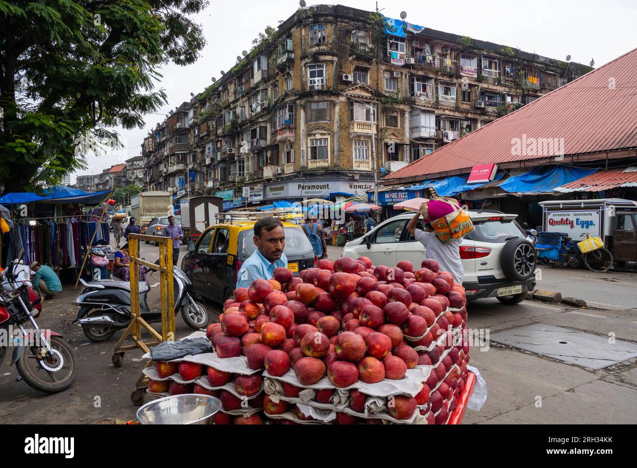 MUMBAI - SEPTEMBER 22: Indischer Verkäufer mit roten Äpfeln auf einem Tablett auf einem lokalen Straßenmarkt in Mumbai am 22. September. 2022 in Indien Stockfoto