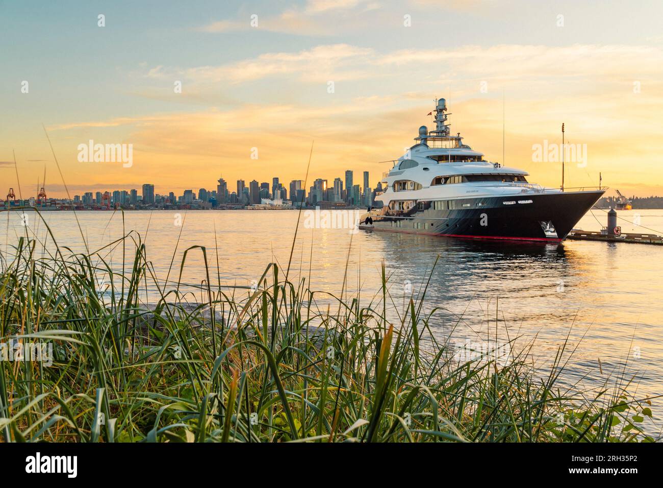 Eine große Luxusyacht liegt im Hafen von Vancouver vor Anker mit Blick auf die Stadt im Hintergrund in Vancouver, Kanada Stockfoto