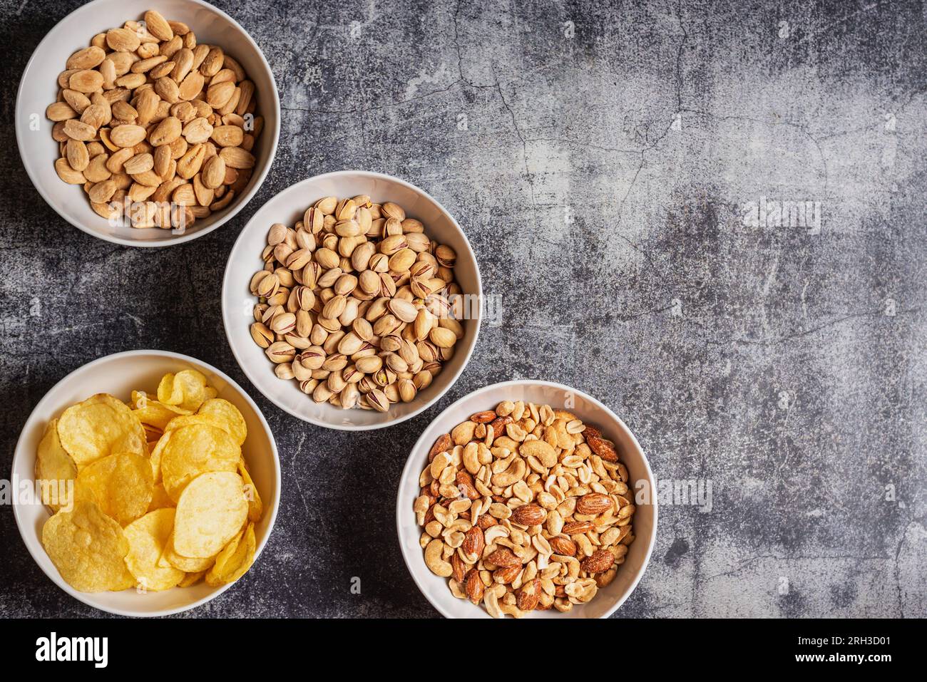 Schüsseln mit Pommes und Nüssen, Mandeln, Pistazien und einer Mischung aus Erdnüssen, Cashews, Haselnüssen und gerösteten Mandeln. Stockfoto