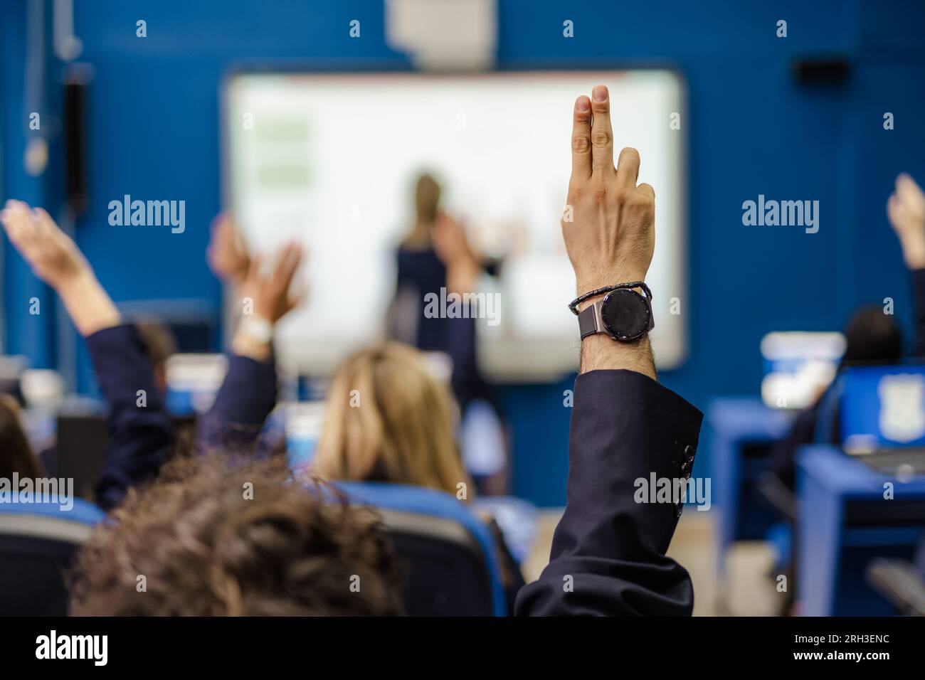 Ein Foto von Schülern, die während des Vortrags in der Schule die Hand heben und Fragen stellen Stockfoto
