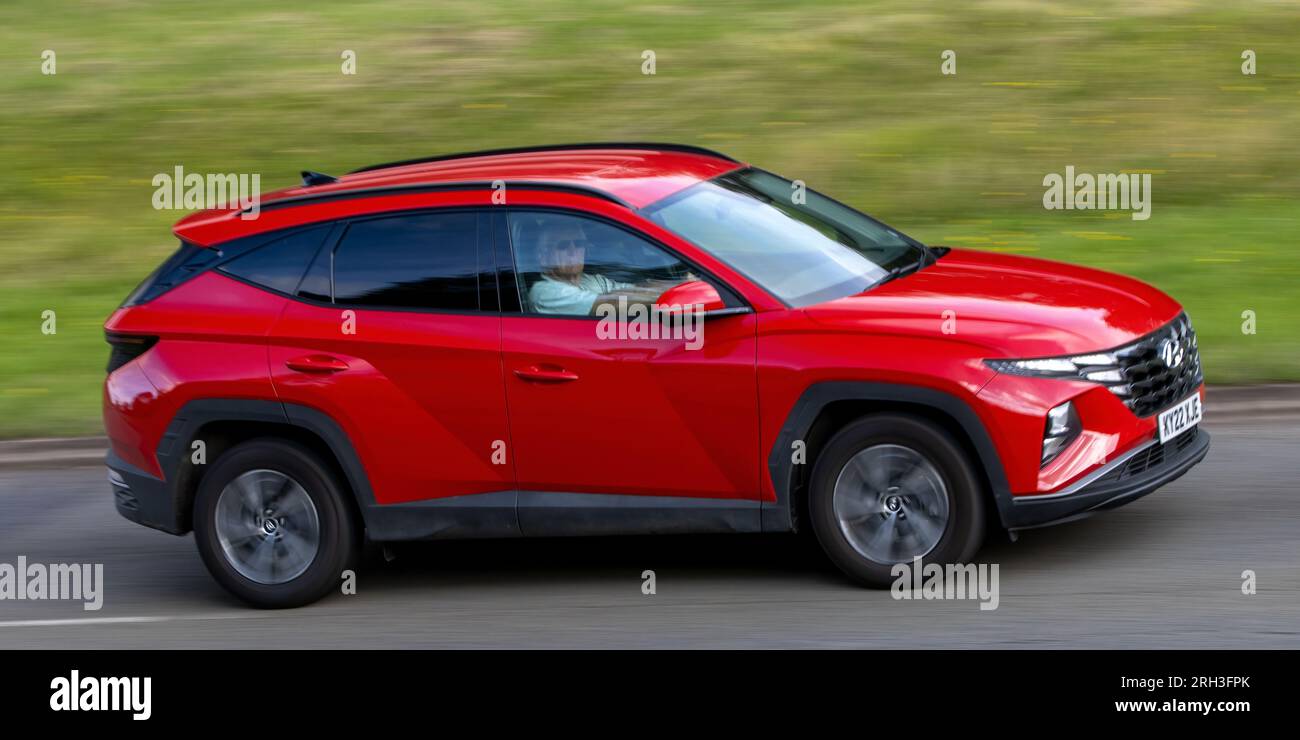 Milton Keynes, Großbritannien - Aug 10. 2023: 2022 Red Hundai Tucson Hybrid-Elektroauto, das auf einer englischen Landstraße fährt. Stockfoto